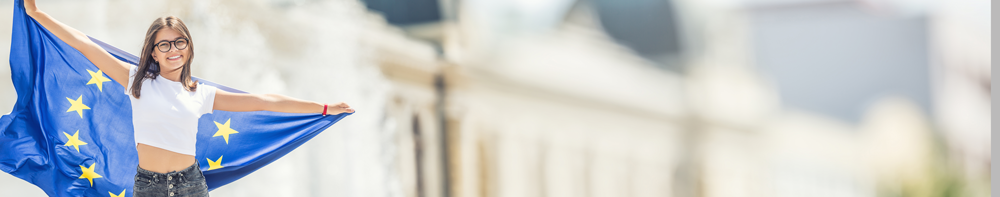 cute happy young girl with the flag of the european union in front of a historic building somewhere in europe 1
